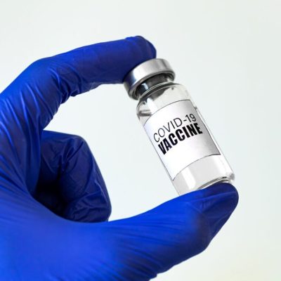 Banner with vaccine vial in hand, doctor holding vaccine bottle in hospital